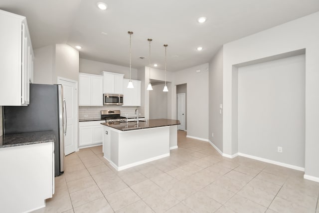 kitchen featuring stainless steel appliances, a center island with sink, light tile patterned floors, hanging light fixtures, and white cabinets