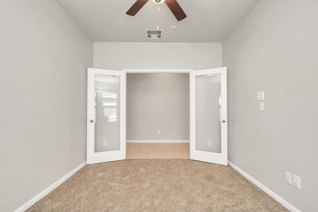 unfurnished bedroom featuring french doors, light carpet, and ceiling fan