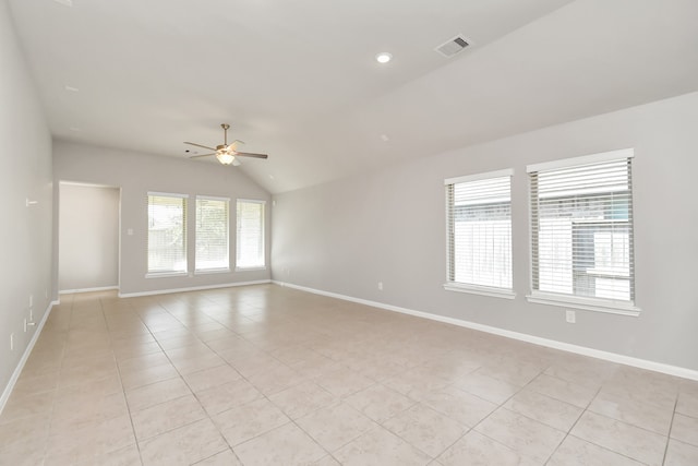 empty room with vaulted ceiling, light tile patterned floors, and ceiling fan