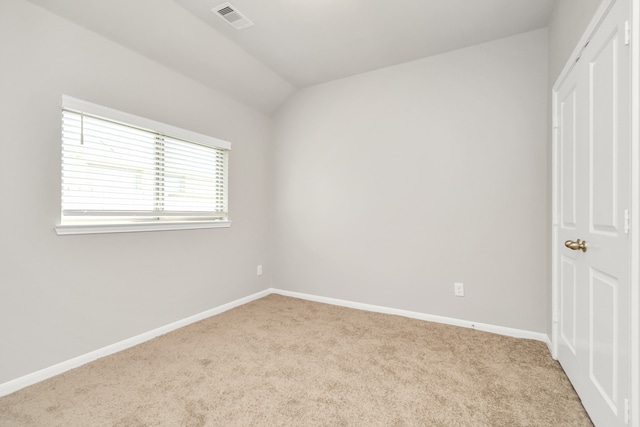 unfurnished bedroom featuring vaulted ceiling and light colored carpet