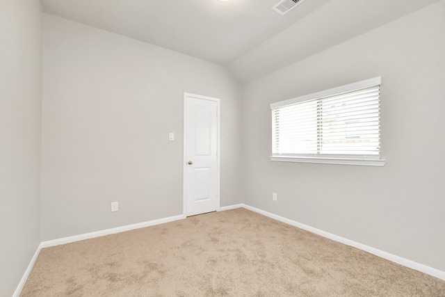 carpeted spare room featuring lofted ceiling