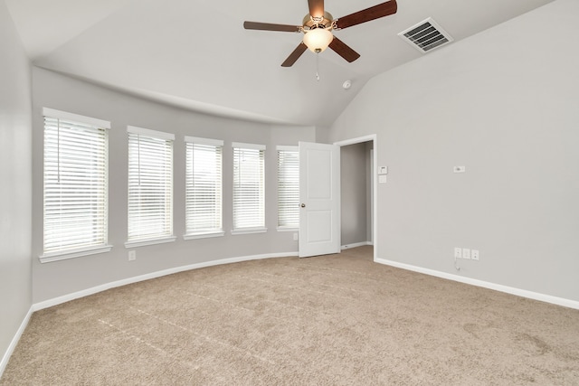 empty room with light carpet, ceiling fan, and vaulted ceiling