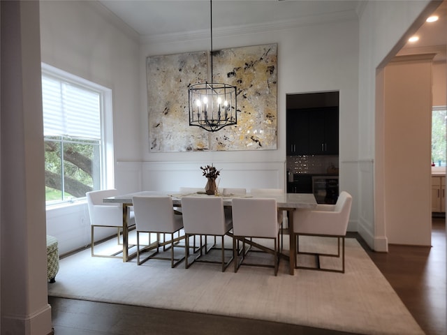 dining space featuring dark hardwood / wood-style flooring, a notable chandelier, and crown molding