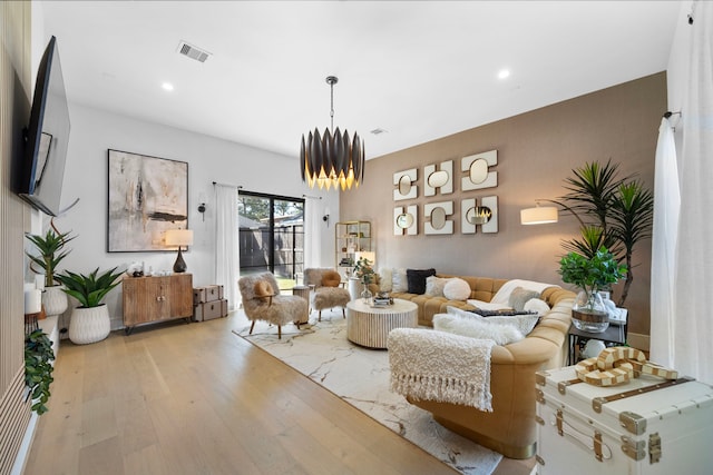 living room featuring an inviting chandelier and light wood-type flooring