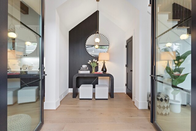 corridor featuring vaulted ceiling and light hardwood / wood-style floors