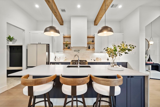 kitchen featuring stainless steel refrigerator, island range hood, hanging light fixtures, and white cabinets