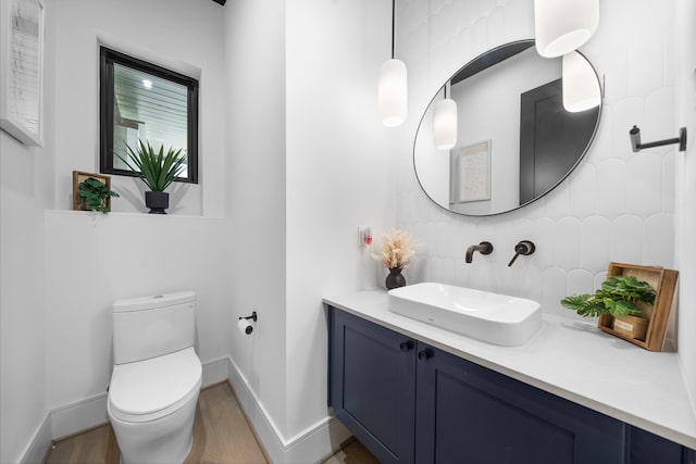 bathroom with vanity, hardwood / wood-style floors, decorative backsplash, and toilet