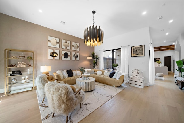 living room with a notable chandelier and light hardwood / wood-style floors