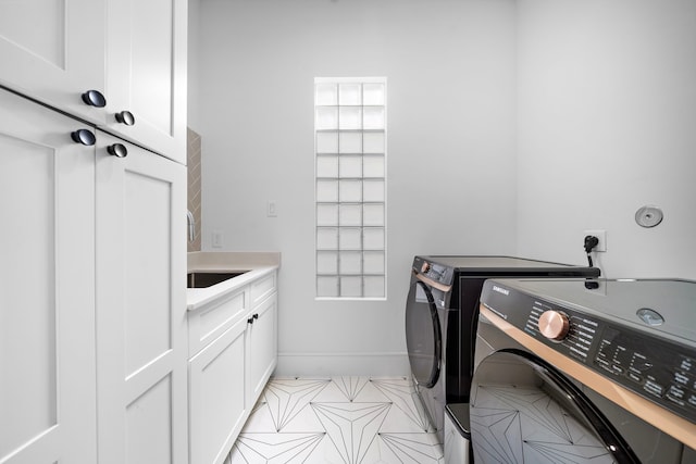 laundry area featuring cabinets, washer and dryer, and sink