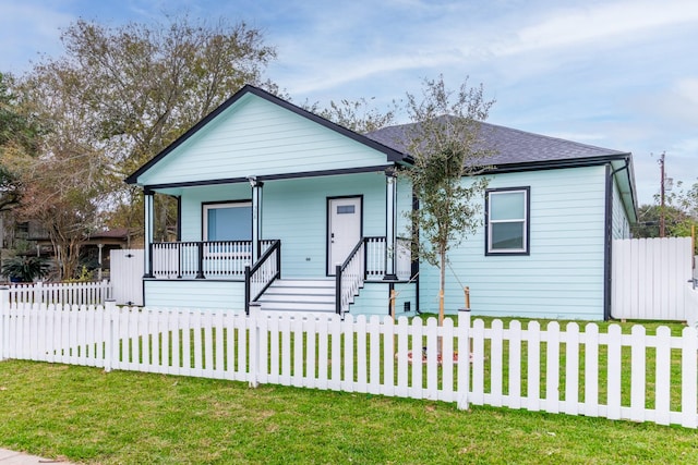 view of front of home with covered porch and a front lawn