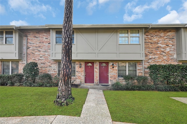 townhome / multi-family property featuring a front lawn