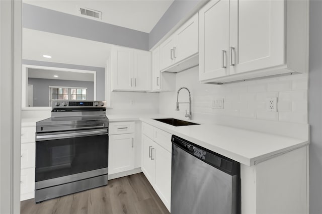 kitchen featuring white cabinets, hardwood / wood-style flooring, stainless steel appliances, and sink