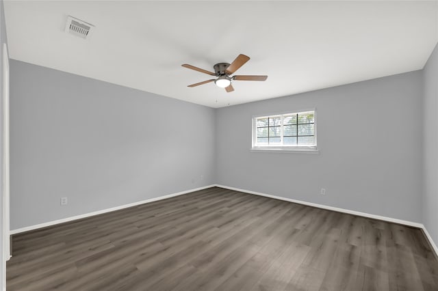 empty room featuring dark wood-type flooring and ceiling fan