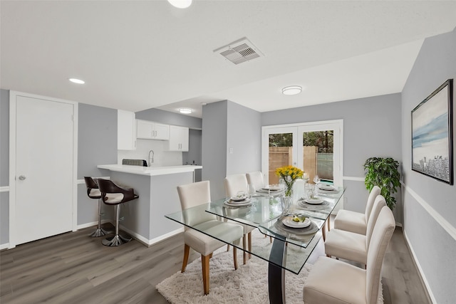 dining room featuring dark wood-type flooring, sink, and french doors