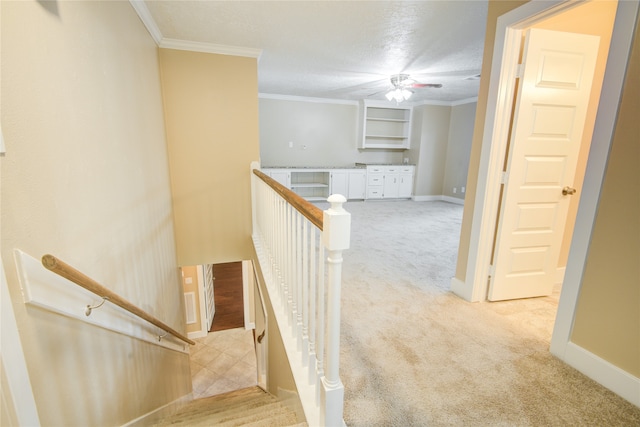 corridor featuring light colored carpet, a textured ceiling, and crown molding