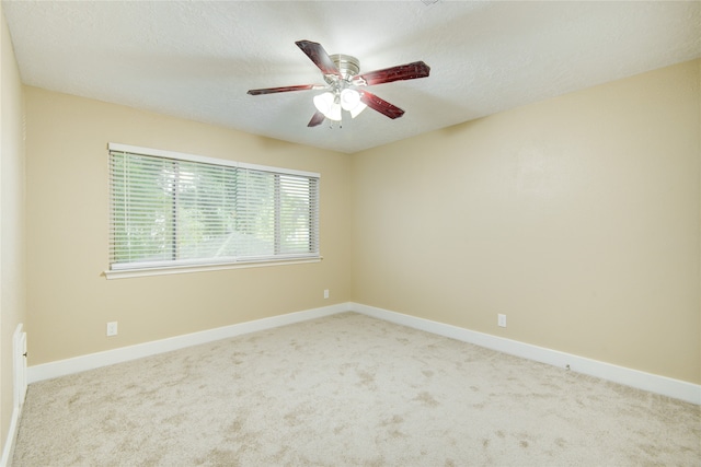 unfurnished room with a textured ceiling, light carpet, and ceiling fan