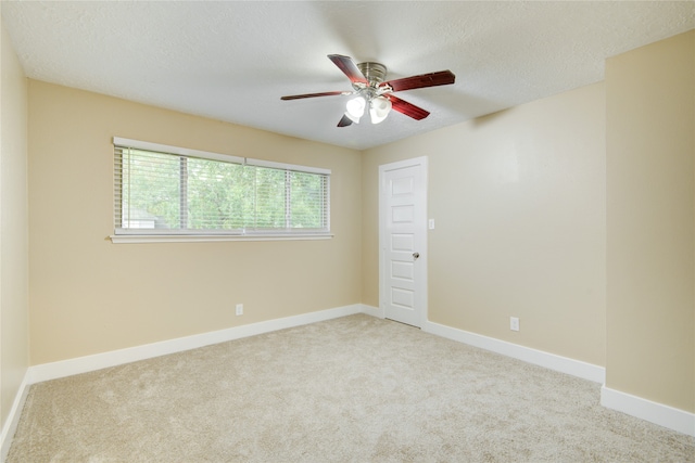 carpeted spare room featuring a textured ceiling and ceiling fan