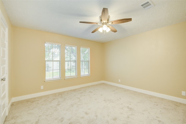 carpeted empty room featuring ceiling fan and a textured ceiling