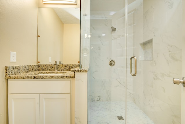 bathroom with walk in shower and vanity