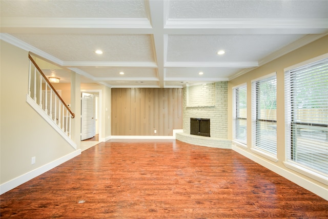 unfurnished living room featuring hardwood / wood-style floors, beamed ceiling, ornamental molding, and coffered ceiling