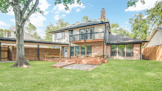 back of house with a patio, a lawn, and a balcony