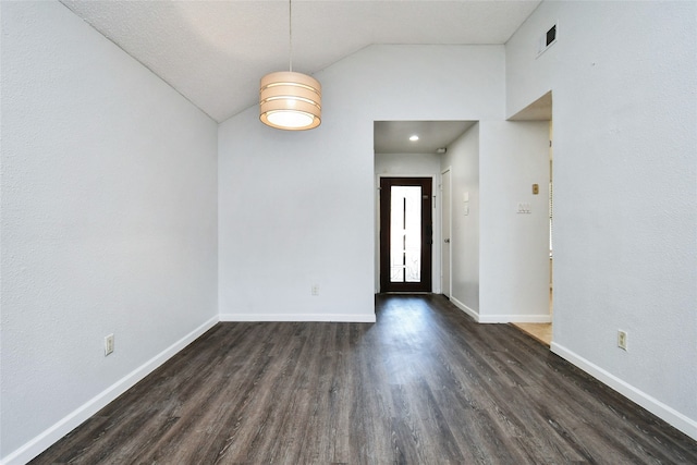 empty room with dark wood-type flooring and lofted ceiling