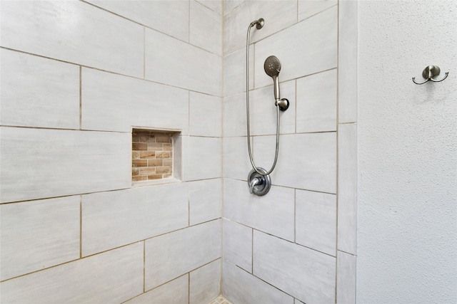 interior details featuring tiled shower