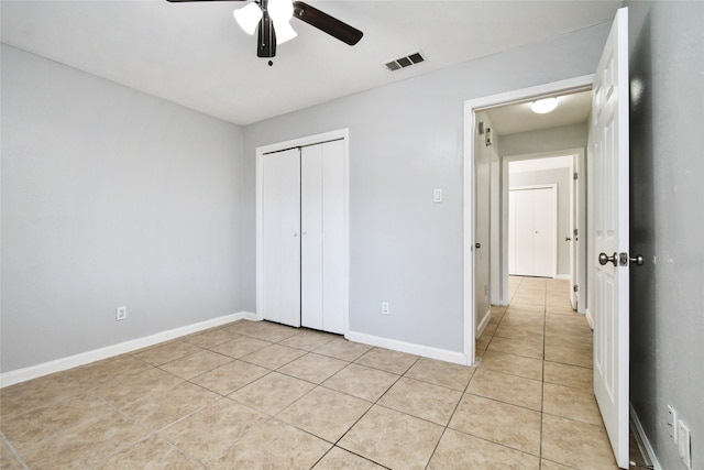 unfurnished bedroom featuring a closet, light tile patterned floors, and ceiling fan