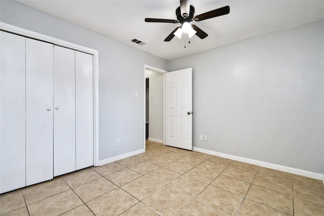 unfurnished bedroom featuring light tile patterned floors, ceiling fan, and a closet