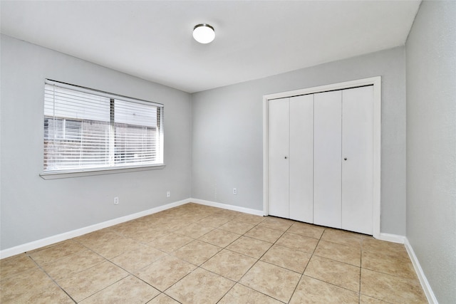 unfurnished bedroom with a closet and light tile patterned floors