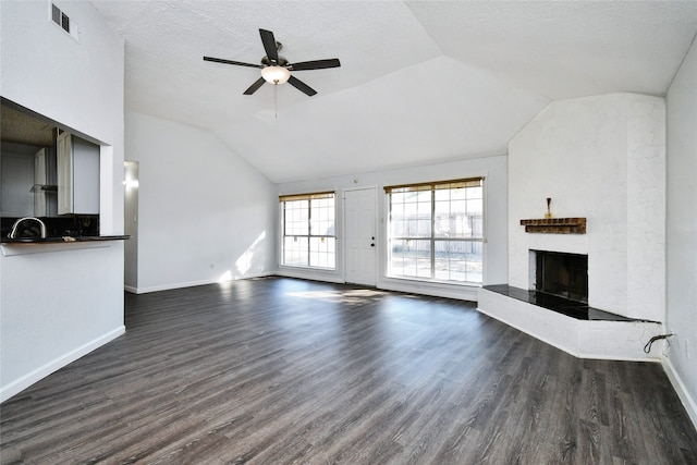 unfurnished living room featuring a textured ceiling, dark wood-type flooring, ceiling fan, and lofted ceiling