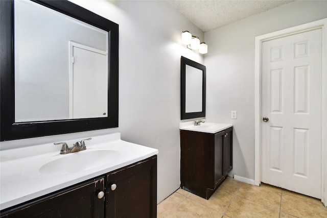 bathroom with vanity, a textured ceiling, and tile patterned floors