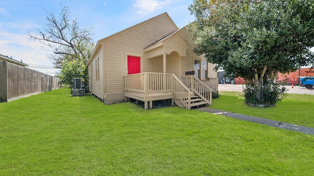 view of front of property with central AC unit and a front yard