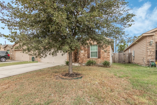 view of property hidden behind natural elements featuring a garage and a front lawn