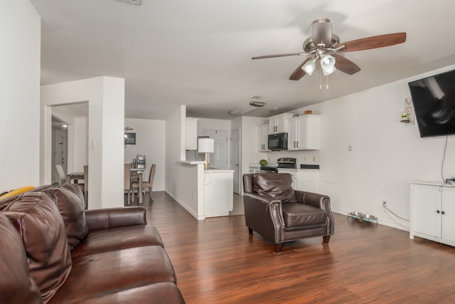 living room with ceiling fan and dark hardwood / wood-style floors