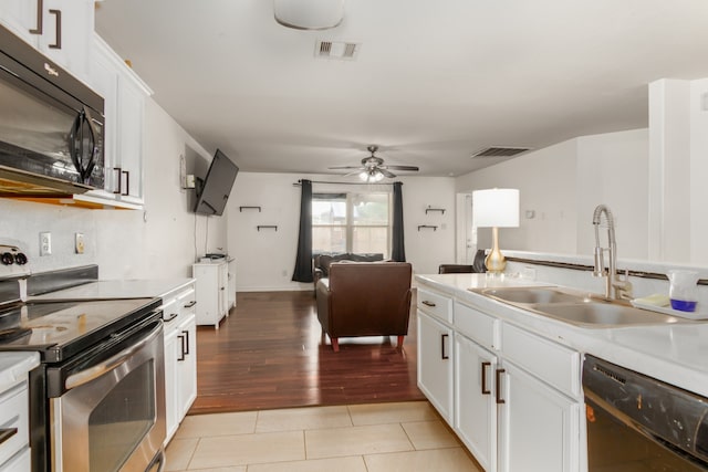 kitchen featuring white cabinetry, light hardwood / wood-style floors, black appliances, and sink