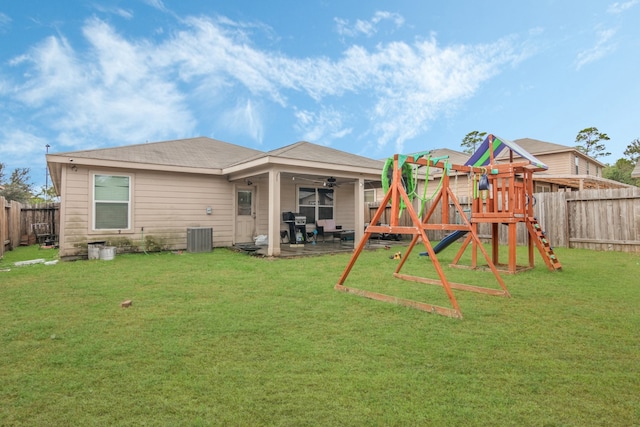 back of property with ceiling fan, a playground, a yard, and a patio area