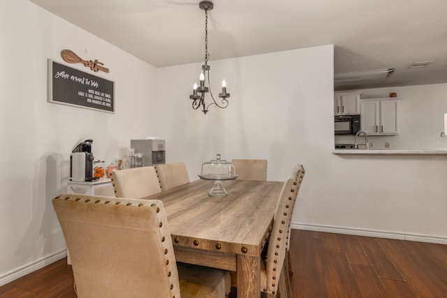 dining room with a chandelier, sink, and dark hardwood / wood-style flooring