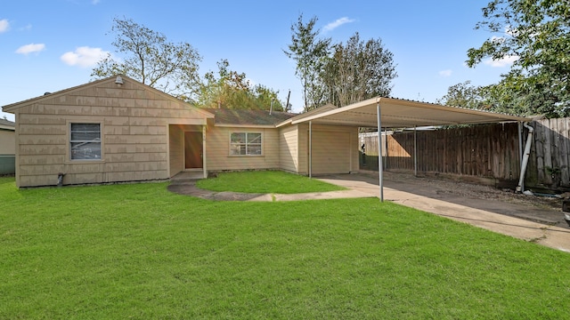 rear view of property featuring a yard and a carport