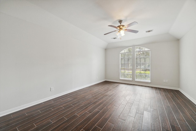 empty room featuring dark hardwood / wood-style flooring, vaulted ceiling, and ceiling fan