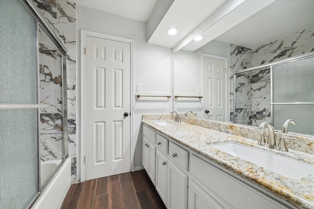 bathroom with combined bath / shower with glass door, vanity, and hardwood / wood-style floors