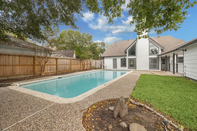 view of swimming pool with a yard