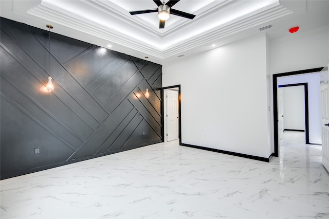 unfurnished room with a towering ceiling, ceiling fan, crown molding, and a tray ceiling