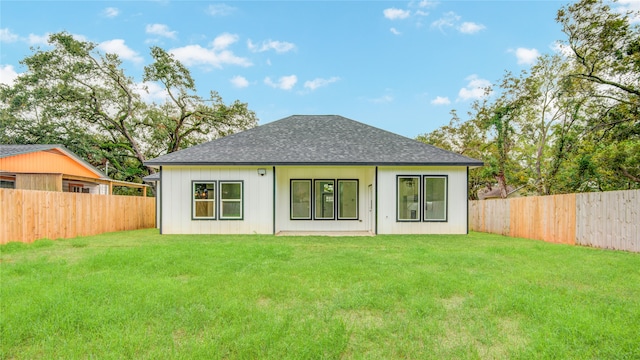 rear view of property featuring a yard