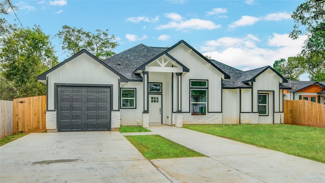 modern inspired farmhouse featuring a garage and a front lawn