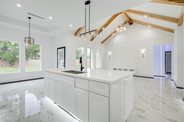 kitchen featuring white cabinetry, sink, high vaulted ceiling, an island with sink, and pendant lighting