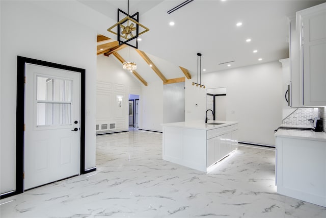 kitchen featuring an inviting chandelier, an island with sink, high vaulted ceiling, beamed ceiling, and decorative light fixtures