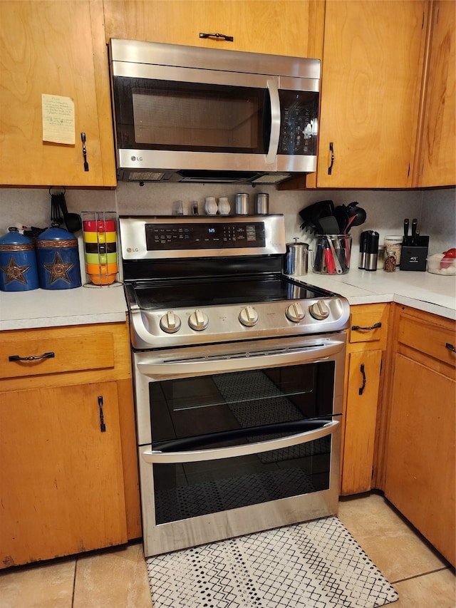 kitchen with light tile patterned flooring and stainless steel appliances