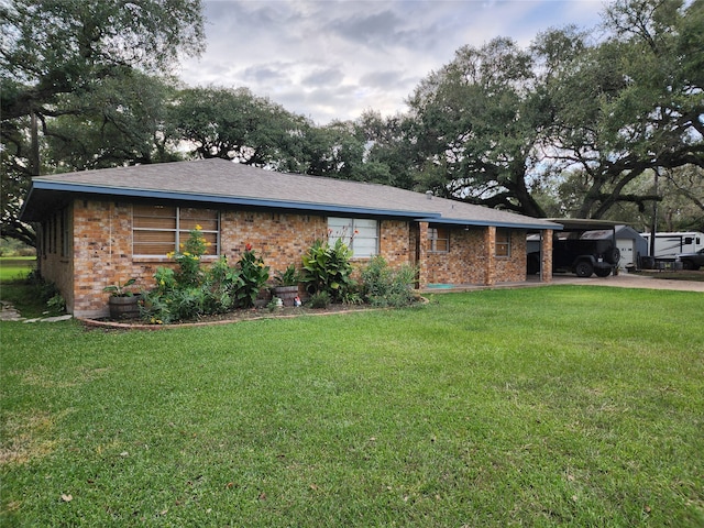 ranch-style home featuring a carport and a front lawn