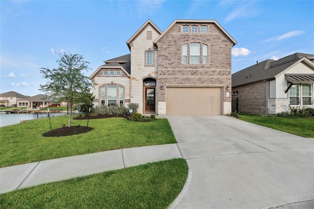 view of front of house with a garage, a water view, and a front yard